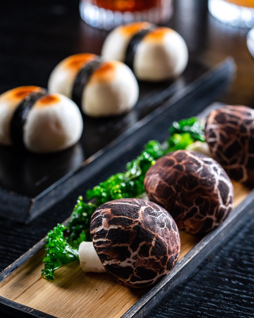 Mushrooms served with greens on a rectangle dish
