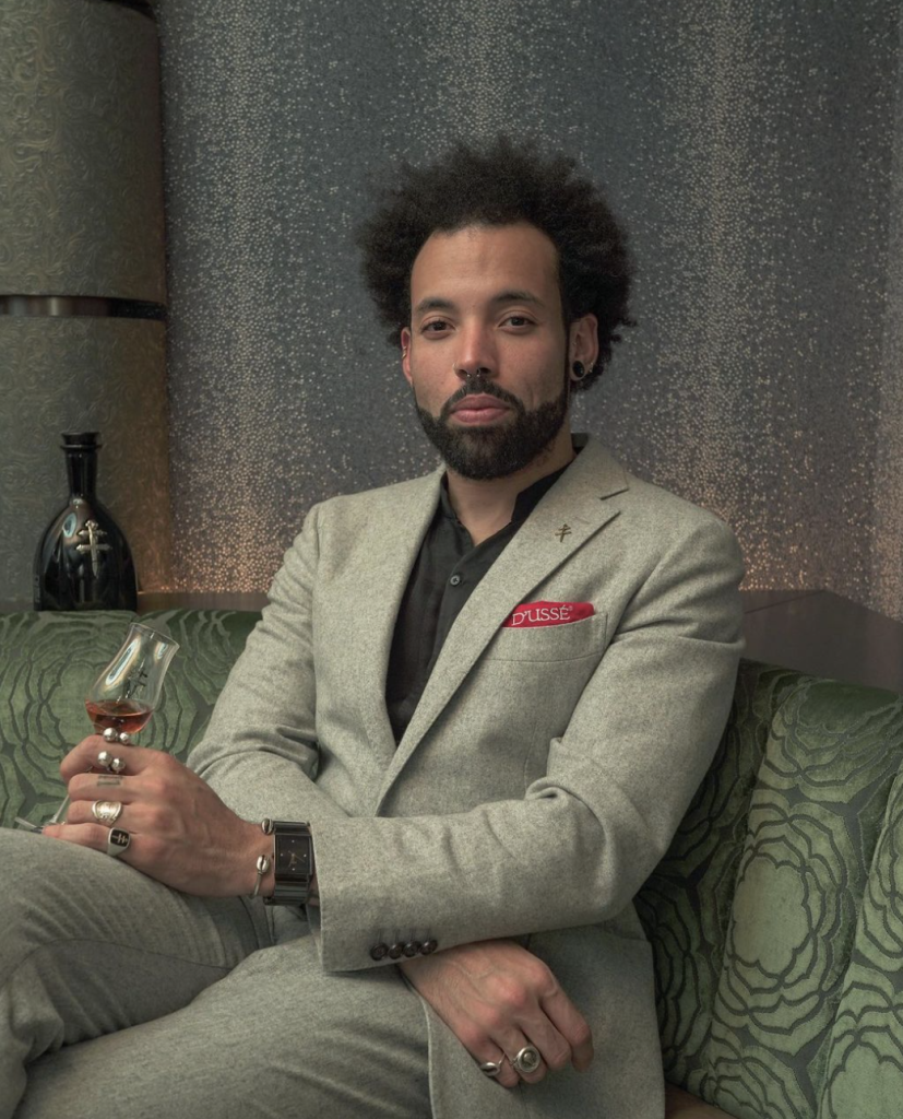 Sullivan Doh in a green suit, sat with a drink